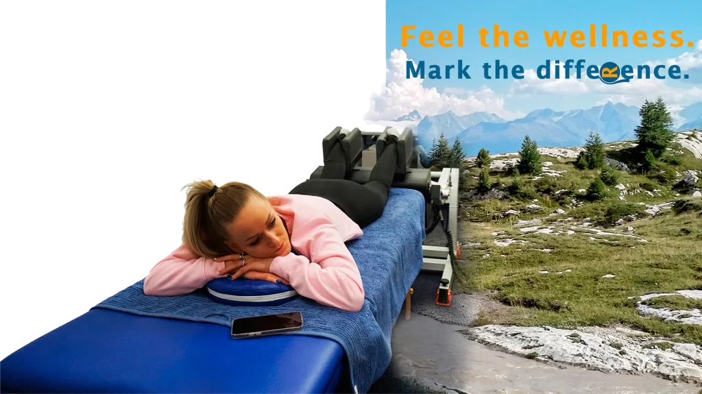 Person lying on a treatment table using the MRM Wellness device, with a mountainous landscape in the background and the slogan “Feel the wellness. Mark the difference.”